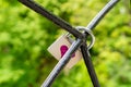 The lock, a symbol of love and loyalty, hangs on iron bars. Red Heart painted on the lock. A piece of iron tree with love locks in