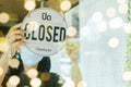 Lockdown. asian female staff wearing protection face mask turning Closed sign board with Thai language on glass door in cafe Royalty Free Stock Photo