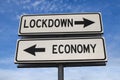 Lockdown and economy white two arrows signs on metal pole. Directional road. Crossroads Road Sign, Two Arrows against blue sky