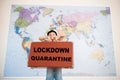 Lockdown quarantine cancel travel concept of little caucasian boy in captain hat holding case with slogan on world map background Royalty Free Stock Photo