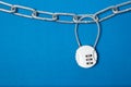 Cipher padlock on chain on blue background. Security concept.