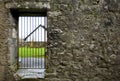 Locked gate in old stone wall Royalty Free Stock Photo