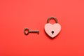 a locked heart shape padlock with key on a red background Royalty Free Stock Photo