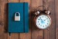 Locked and key on Blue notebook on wooden background