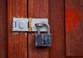 Locked padlock with chain at red wooden door background, vintage Royalty Free Stock Photo