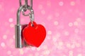 Locked padlock with a red plastic heart on pink Royalty Free Stock Photo