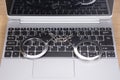 Locked pair of handcuffs on a laptop keyboard Royalty Free Stock Photo