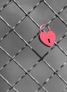 Locked red heart shaped padlock on a bridge