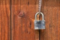 Locked steel padlock hanging on wooden door Royalty Free Stock Photo