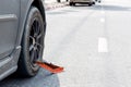 Locked wheel of a car parked in an improper place. Car wheels locked, traffic violation. Black car get locked up by the police.