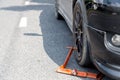 Locked wheel of a car parked in an improper place. Car wheels locked, traffic violation. Black car get locked up by the police.