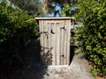 Locked wood outhouse bathroom and green plants Royalty Free Stock Photo