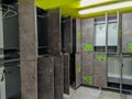 Lockers open in a modern locker room in grey and green colors with numbers, changing clothes to get ready for a workout at a gym