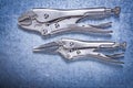 Locking pliers with jaws on metallic background construction con Royalty Free Stock Photo