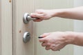 Locking up or unlocking door with key in hand. Royalty Free Stock Photo