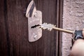 Locking up or unlocking door with key in hand. Side view. Royalty Free Stock Photo