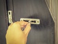 Locking the wooden door with a metal door chain Royalty Free Stock Photo