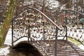 Locks hang in large numbers on the metal railings of the bridge over the river Royalty Free Stock Photo