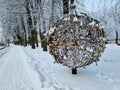 Locks of love hung on a metal tree in the form of a ball in winter, in needle-like frost.
