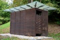 Locks of a tool house in a large public park. serves as a public toilet. It has brown wood paneling and a glass roof with overlaps