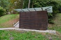 Locks of a tool house in a large public park. serves as a public toilet. It has brown wood paneling and a glass roof with overlaps