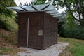 Locks of a tool house in a large public park. serves as a public toilet. It has brown wood paneling and a glass roof with overlaps