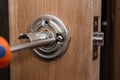 locksmith carpenter fix knob on wooden door by screwdriver for home service reparation Royalty Free Stock Photo