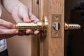 locksmith carpenter fix knob on wooden door by screwdriver for home service reparation Royalty Free Stock Photo