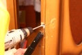 Locksmith repair a door lock and drilling the hole in old door and collect sawdust by vacuum cleaner