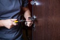 Locksmith replacing door lock to new after losing keys. Robbery protection, safety improvement. Repairman or workman changing or Royalty Free Stock Photo