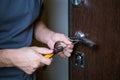 Locksmith replacing door lock to new after losing keys. Robbery protection, safety improvement. Repairman or workman Royalty Free Stock Photo