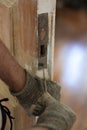 Locksmith use old screwdriver fix the lock on old wooden door Royalty Free Stock Photo