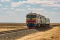 Locomotive train is passing through Kazakhstan desert Royalty Free Stock Photo