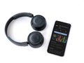 Smartphone with Plex app play store page and wireless headphones on white background Royalty Free Stock Photo