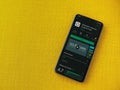 SoloLearn - Learning coding app play store page on the display of a black mobile smartphone on a yellow fabric background
