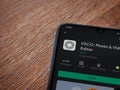 VSCO - Photo and Video Editor app play store page on mobile smartphone on wooden background