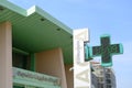 Lodi hospital. Entrance to the modern green painted hospital. Pharmacy cross sign