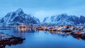 Lofoten islands, Norway. Colorful winter landscape in blue hour. Fjord, fishing village, snowy mountains.