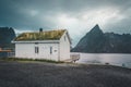 Lofoten Islands Norway - September 2018: House with traditional grass roof and mountains in the background on a cloudy Royalty Free Stock Photo