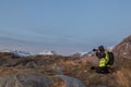 Lofoten, Norway- Mars 12 2020: Photographer woman photographs the Norwegian fjords during sunset time