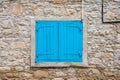 Lofou, Limassol District, Cyprus - Textured brick stone wall and blue window shutters