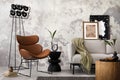 Loft and indiustral interior design of living room interior with mock up poster frame, leather brown armchair, modern black lamp, Royalty Free Stock Photo