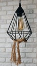 Loft lamp in the interior, a lamp against a brick wall, a pendant lamp decorated with a rope. Royalty Free Stock Photo