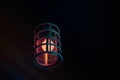 Loft pendant lamp with red blue glow in steel rebar shade, wooden interior background, copy space