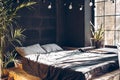 Loft style bedroom. Bed with wood steps with black bed Modern room interior with dark furniture