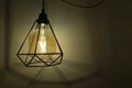 Loft style lamp hanging on a string on a wall in a room. Lighting effect of a modern light bulb Royalty Free Stock Photo