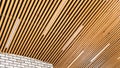 Loft style wooden plank ceiling design idea. Slatted wooden ceiling in the interior. Designer ceiling close-up. LED strip lamps in