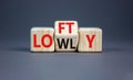 Lofty or lowly symbol. Concept words Lofty Lowly on wooden block. Beautiful grey table grey background. Business lofty or lowly