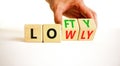 Lofty or lowly symbol. Concept words Lofty Lowly on wooden block. Beautiful white table white background. Businessman hand.