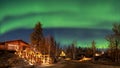 A log cabin in pine forest under Aurora borealis at YellowKnife